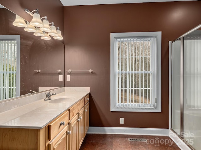 bathroom featuring a wealth of natural light, a shower stall, and baseboards