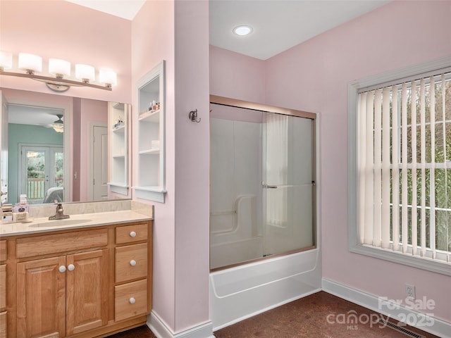 ensuite bathroom featuring ensuite bathroom, baseboards, enclosed tub / shower combo, ceiling fan, and vanity