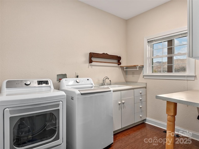 laundry room with a sink, baseboards, washer and clothes dryer, cabinet space, and dark wood-style flooring