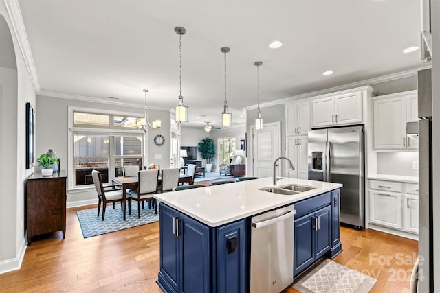 kitchen featuring stainless steel appliances, sink, blue cabinetry, light hardwood / wood-style flooring, and white cabinets