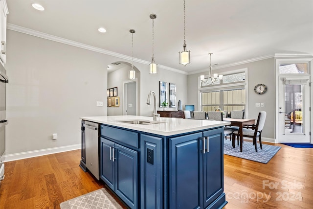 kitchen with hardwood / wood-style floors, sink, blue cabinets, and a kitchen island with sink