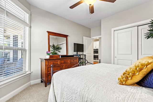 carpeted bedroom with ceiling fan and a closet