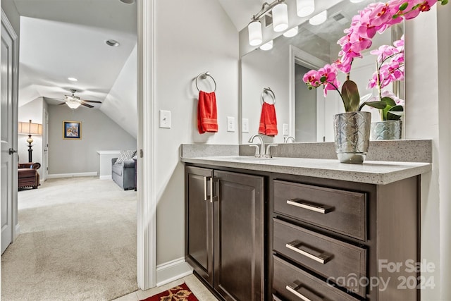 bathroom with ceiling fan, vanity, and vaulted ceiling