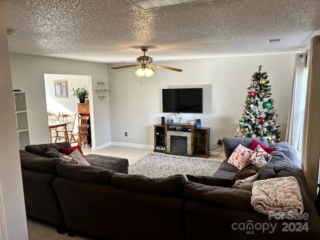 living room featuring light tile patterned floors, a textured ceiling, and ceiling fan