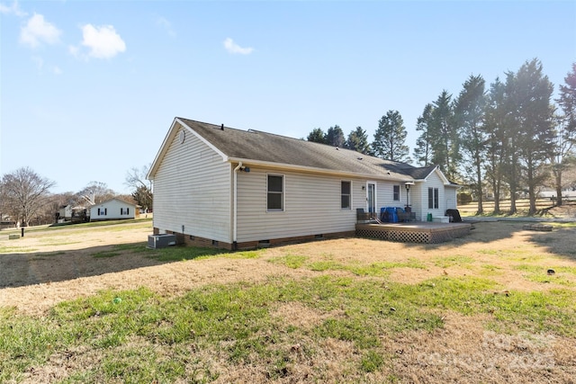 back of house with a lawn, central AC unit, and a deck