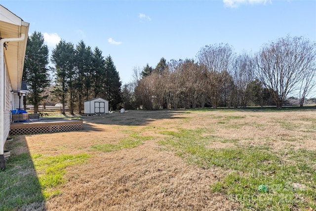 view of yard featuring a storage shed and a wooden deck