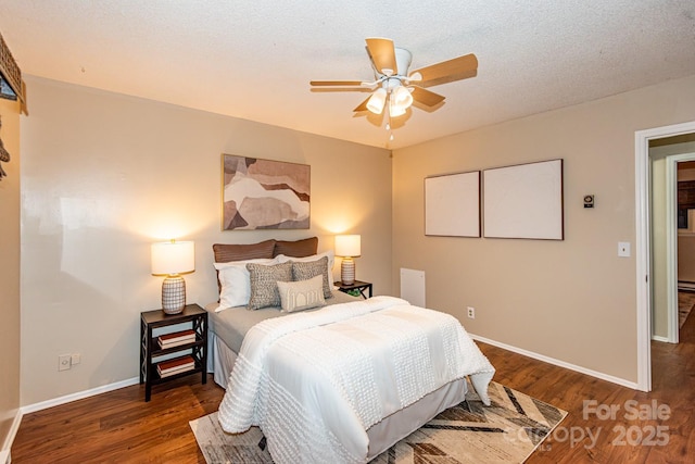 bedroom with ceiling fan, dark wood-type flooring, and a textured ceiling