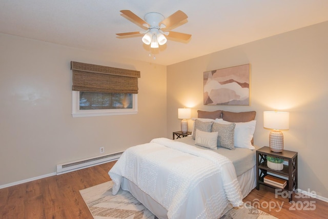 bedroom featuring hardwood / wood-style flooring, ceiling fan, and a baseboard radiator