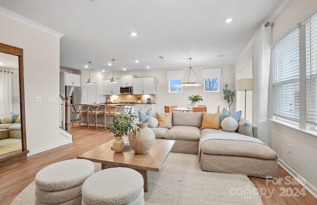 living room featuring light hardwood / wood-style flooring and ornamental molding