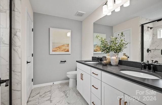 bathroom with a shower with door, vanity, and toilet