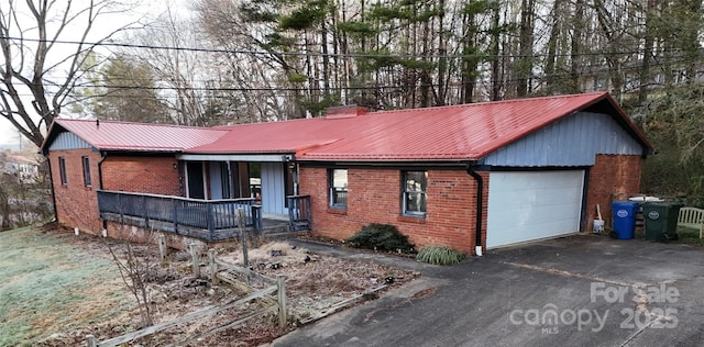 single story home with a porch and a garage