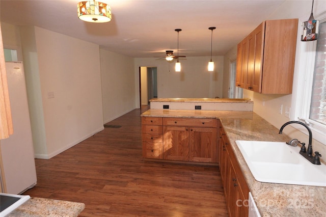 kitchen featuring kitchen peninsula, ceiling fan, sink, white fridge, and dark hardwood / wood-style floors