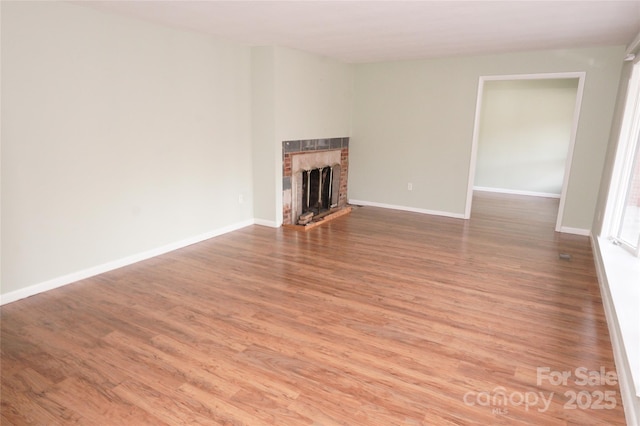 unfurnished living room featuring a fireplace and hardwood / wood-style flooring