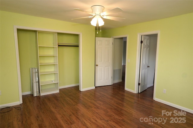 unfurnished bedroom with dark hardwood / wood-style flooring, a closet, and ceiling fan