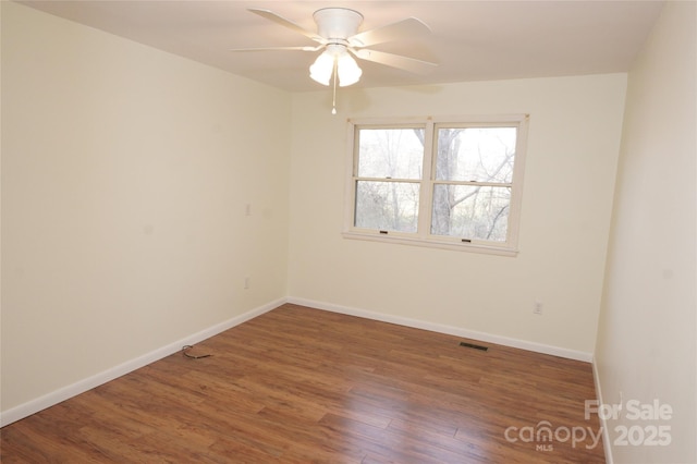 empty room featuring ceiling fan and dark hardwood / wood-style flooring