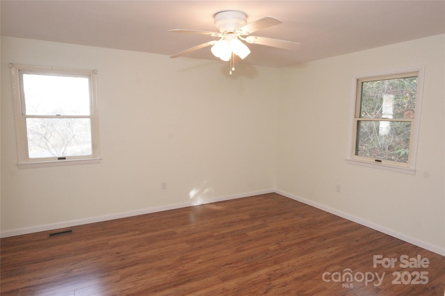 empty room featuring visible vents, baseboards, a ceiling fan, and wood finished floors