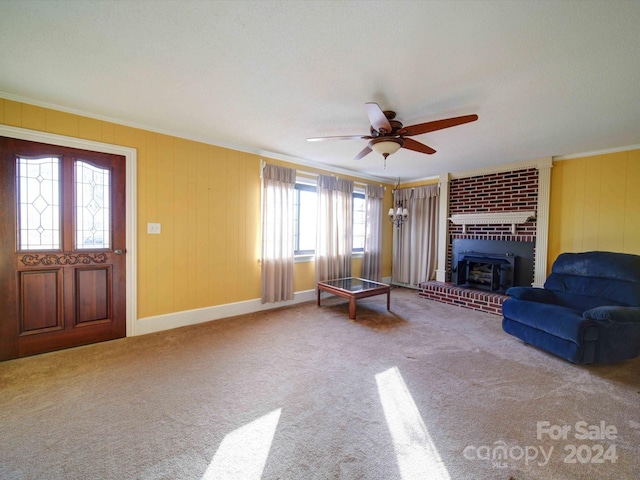 unfurnished living room with carpet flooring, ceiling fan, ornamental molding, and a wood stove