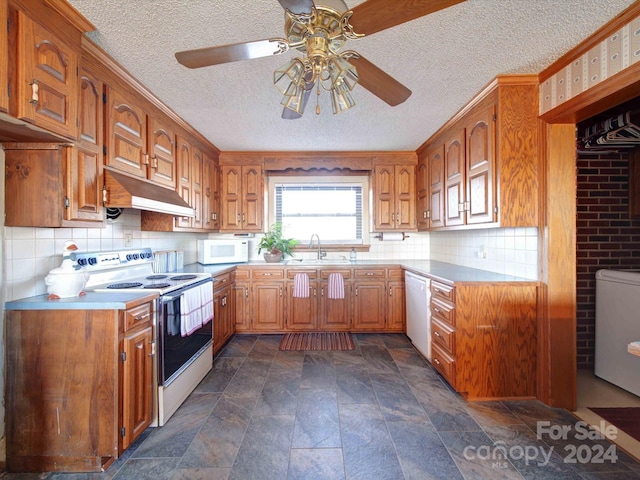 kitchen with ceiling fan, sink, a textured ceiling, white appliances, and decorative backsplash