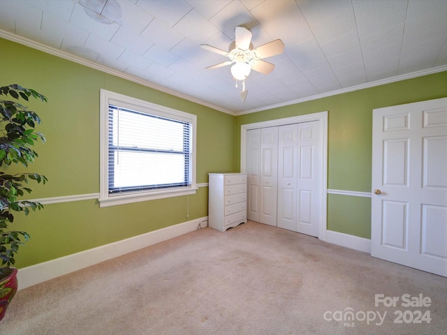 unfurnished bedroom with ceiling fan, crown molding, and light carpet