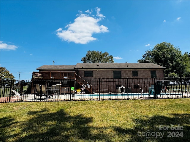 back of property featuring a fenced in pool and a yard