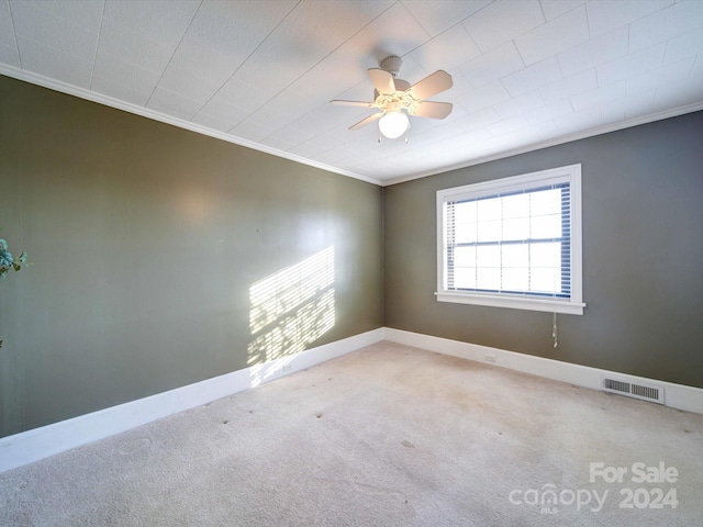 carpeted empty room featuring ceiling fan and ornamental molding