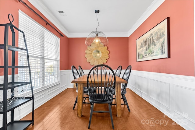 dining area featuring ornamental molding and hardwood / wood-style flooring