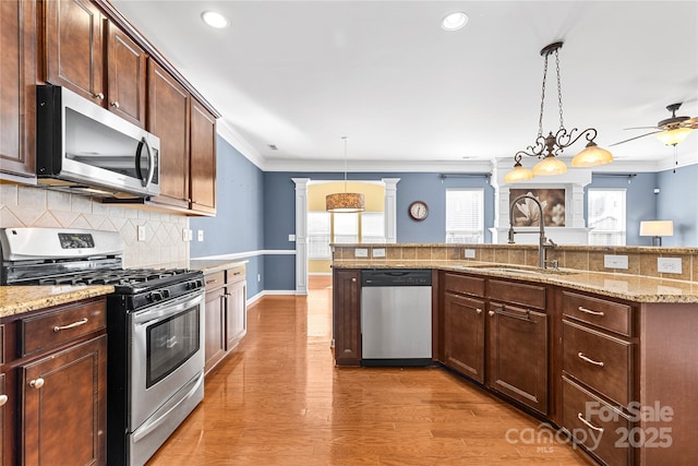 kitchen featuring decorative backsplash, appliances with stainless steel finishes, decorative light fixtures, and sink