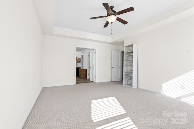 unfurnished bedroom with a tray ceiling, ceiling fan, and light colored carpet