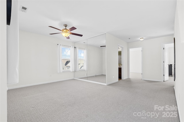 empty room featuring ceiling fan and light colored carpet