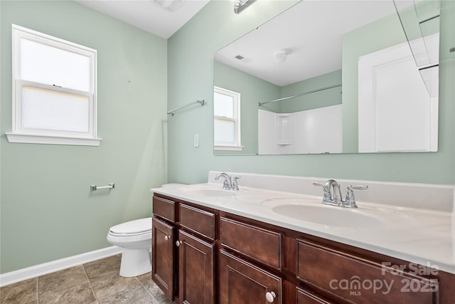 bathroom featuring vanity, toilet, and walk in shower