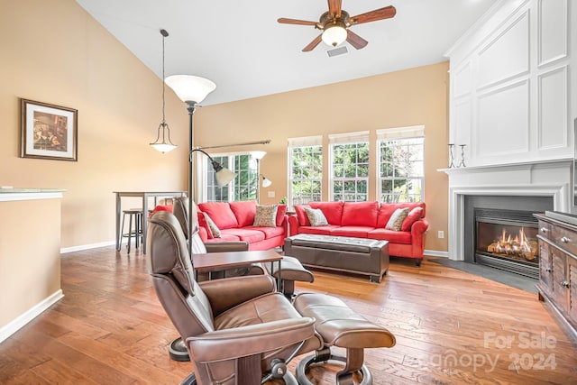 living room with light wood-type flooring, ceiling fan, and lofted ceiling