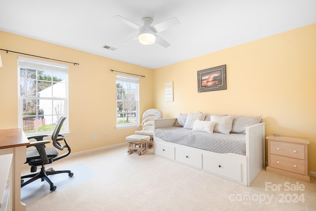 carpeted bedroom featuring ceiling fan and multiple windows