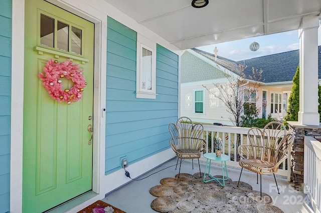 view of exterior entry featuring covered porch