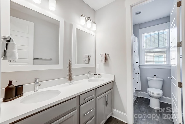 bathroom with hardwood / wood-style flooring, vanity, curtained shower, and toilet