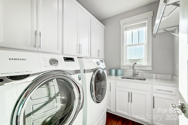 laundry room with washer and dryer, cabinets, and sink