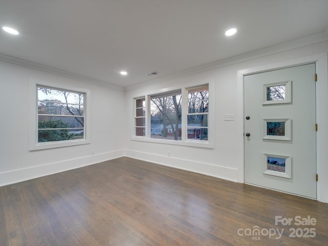 foyer featuring dark wood-type flooring and crown molding