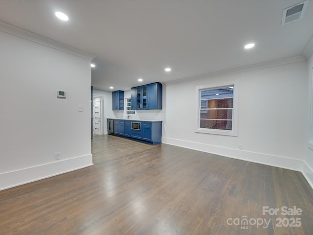 unfurnished living room featuring dark hardwood / wood-style floors, ornamental molding, and sink