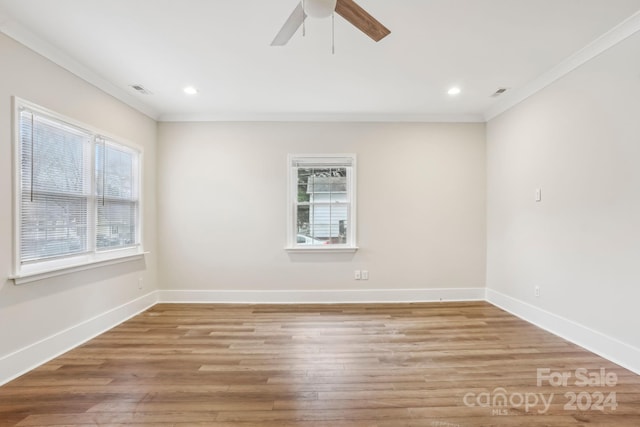 empty room featuring light hardwood / wood-style floors, a healthy amount of sunlight, and ornamental molding