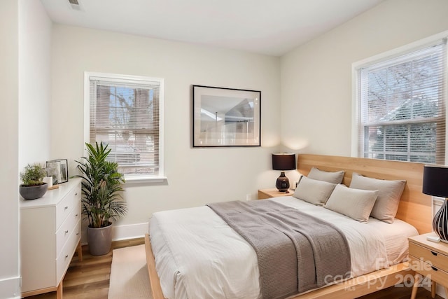 bedroom featuring light hardwood / wood-style flooring and multiple windows