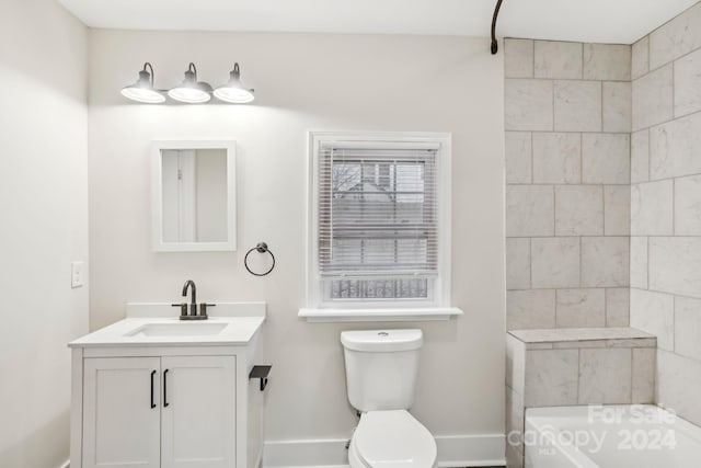 bathroom featuring a washtub, vanity, and toilet