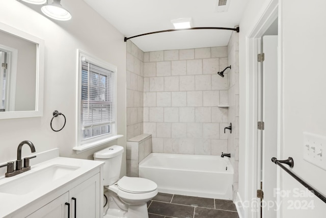 full bathroom featuring tile patterned flooring, vanity, tiled shower / bath combo, and toilet