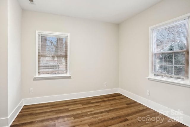 unfurnished room with wood finished floors and baseboards