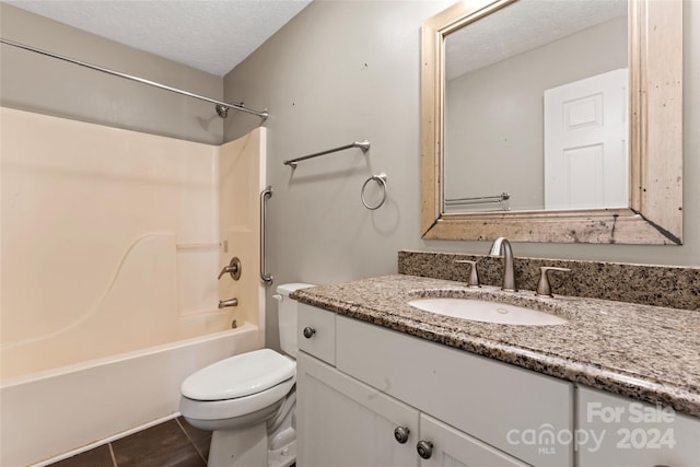 full bathroom featuring tile patterned floors, a textured ceiling, toilet, vanity, and shower / bathtub combination