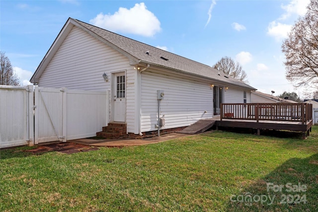 back of house featuring a wooden deck and a lawn