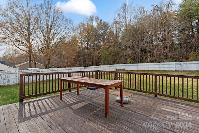 wooden terrace featuring a lawn