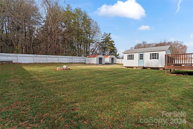 view of yard with a wooden deck and a storage shed