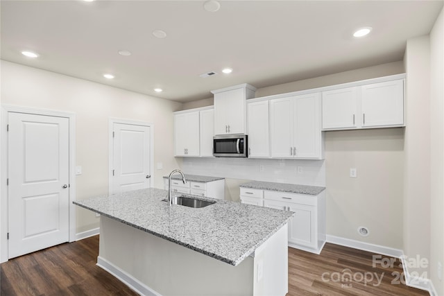 kitchen with a center island with sink, dark hardwood / wood-style floors, white cabinets, and sink