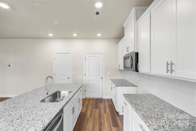 kitchen with white cabinets, sink, dark hardwood / wood-style floors, light stone counters, and stainless steel appliances