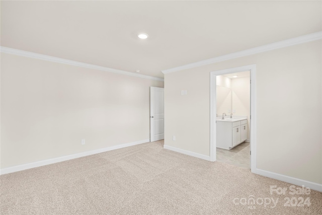 unfurnished bedroom with connected bathroom, light colored carpet, crown molding, and sink