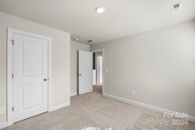 unfurnished bedroom featuring light carpet